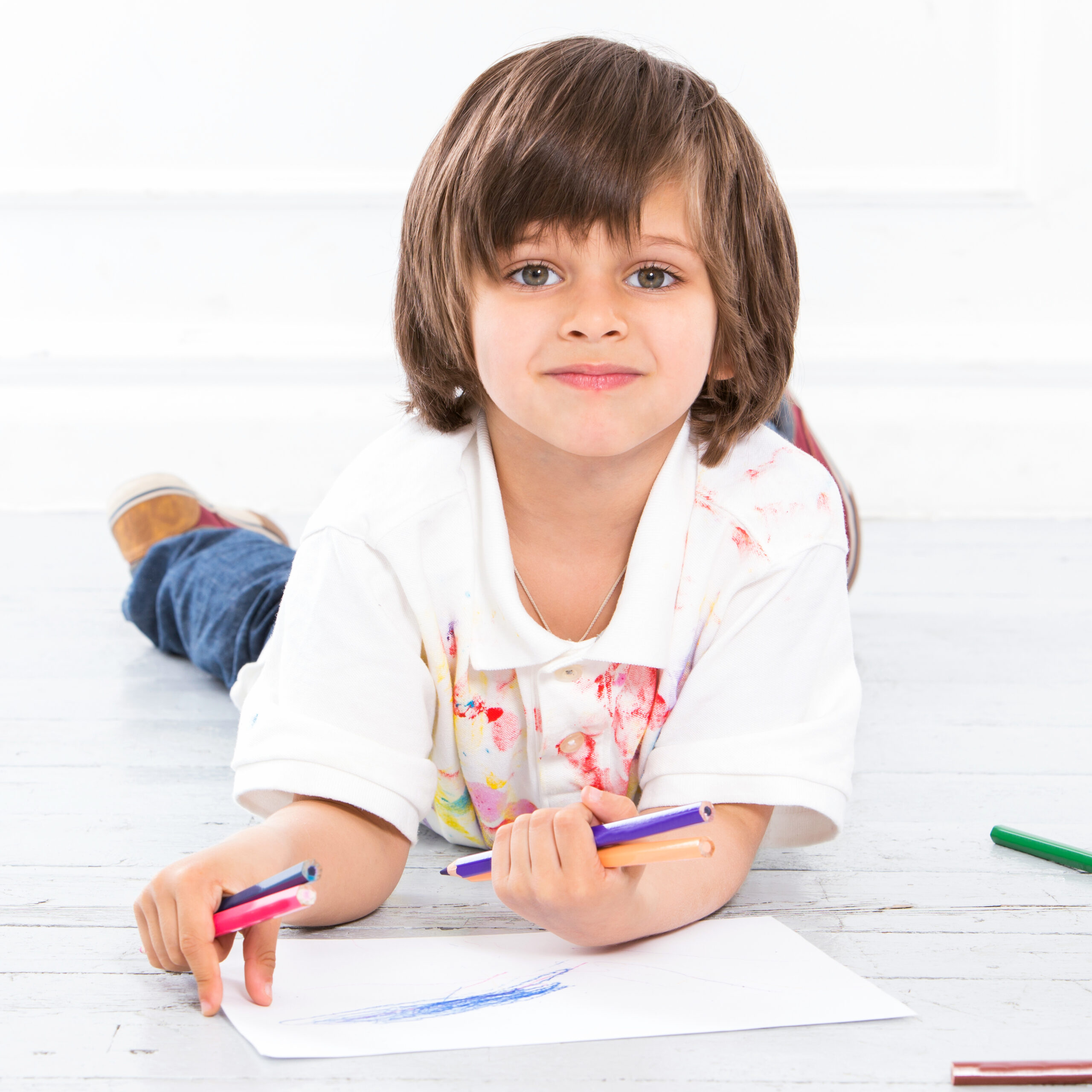 Cute, adorable boy with pencils on the floor